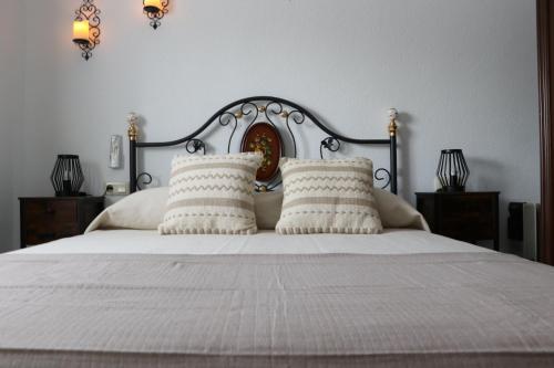 a bedroom with a white bed with two pillows at Villa Calatrue - Tabernas in Tabernas