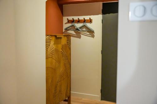 un placard avec une étagère en bois et une porte dans l'établissement Le Clos de St Val 5, à Saint-Valery-sur-Somme