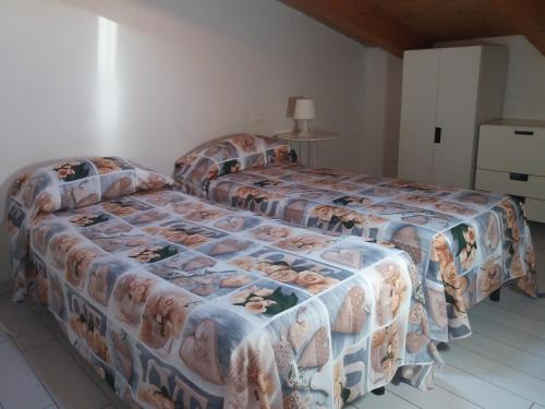 two twin beds in a bedroom with a bedspread with puppies on it at Casa Regina Elena II in Termoli