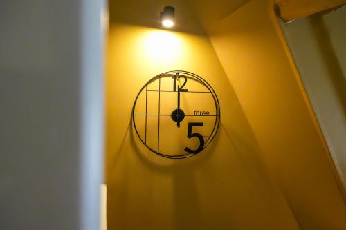 une horloge accrochée à un mur dans une pièce dans l'établissement Le Clos de St Val 6, à Saint-Valery-sur-Somme
