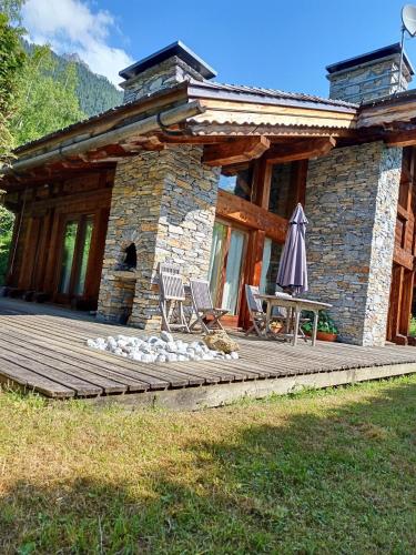 une cabine avec une terrasse dotée d'une table et d'un parasol dans l'établissement Chalet Spacieux à Chamonix pour 9 – Vue Panoramique Mont-Blanc, Jacuzzi, Jardin & Parking, à Chamonix-Mont-Blanc