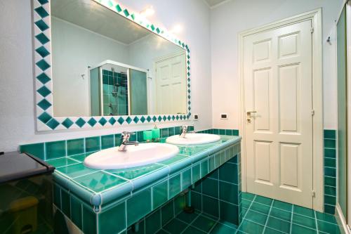 a bathroom with two sinks and a mirror at Villa Mattei in Oristano