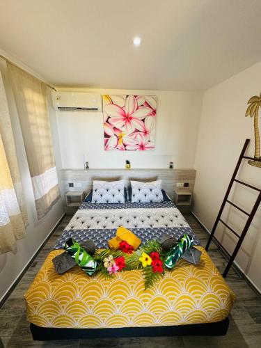 a bedroom with a large bed with flowers on it at Villa Nanihivai - maison moderne avec piscine privée in Faaa