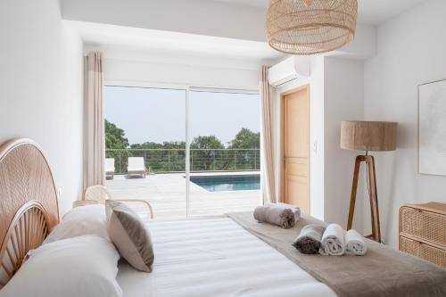 une chambre avec un lit et une grande fenêtre dans l'établissement Villa avec piscine et vue mer à 230m de la plage, à Zonza