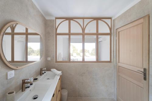 une salle de bain avec un lavabo et un miroir dans l'établissement Villa avec piscine et vue mer à 230m de la plage, à Zonza