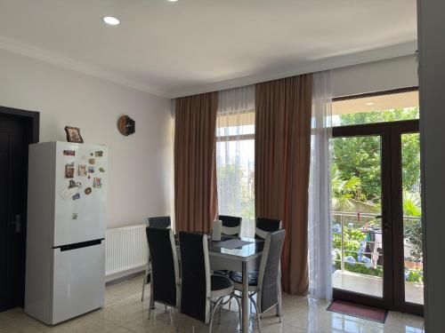una cucina con tavolo con sedie e frigorifero di Lia Guest House a Kobuleti
