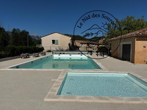 a swimming pool with a sign that reads who does something at Le Nid des Sources in Montbrun-les-Bains