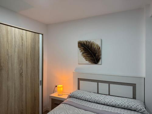 a bedroom with a bed and a table with a lamp at Apartamento céntrico Vinaros 1A in Vinarós