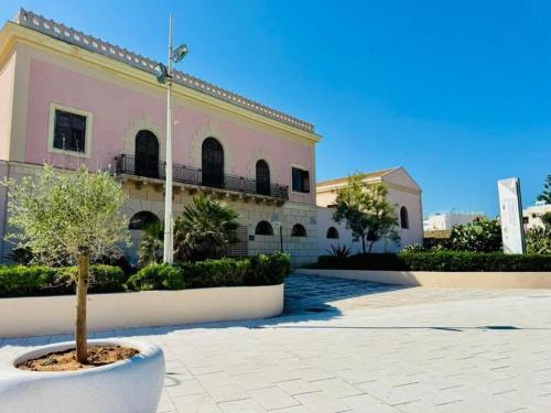 un edificio con un albero di fronte di Casa Monteserrato a Terrasini
