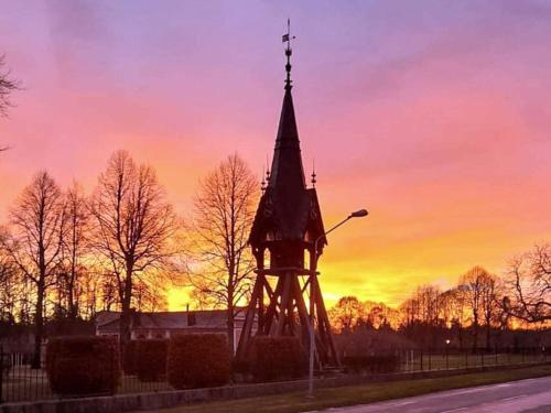 a church steeple with a sunset in the background at 4 person holiday home in LJUSDAL-By Traum in Ljusdal