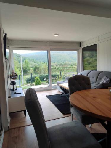 a living room with a table and a large window at Japods Kingdom in Bihać