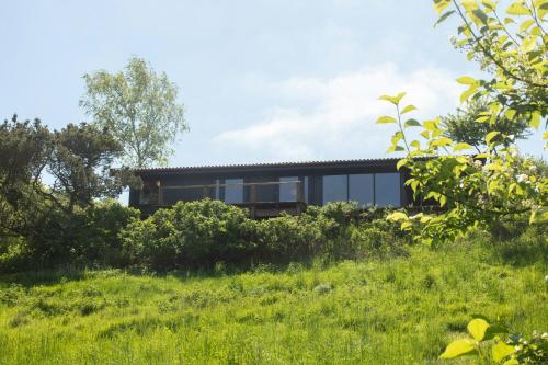 a house on a hill with green grass at Sunsets In A Delightful 70S House in Ris
