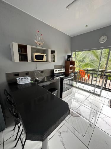 a kitchen with a black counter top in a room at Punta Leona Beach Condos in Jacó