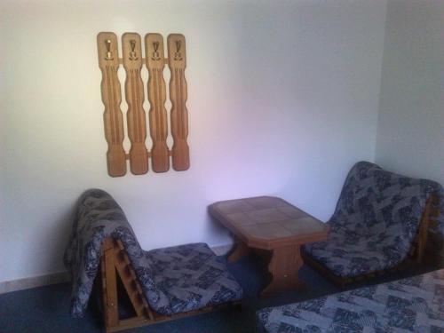a room with two chairs and a table and chopsticks at Pension Baron in Vrchlabí