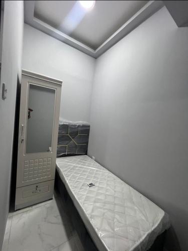 a small room with a bed and a mirror at SARA Apartment in Dubai