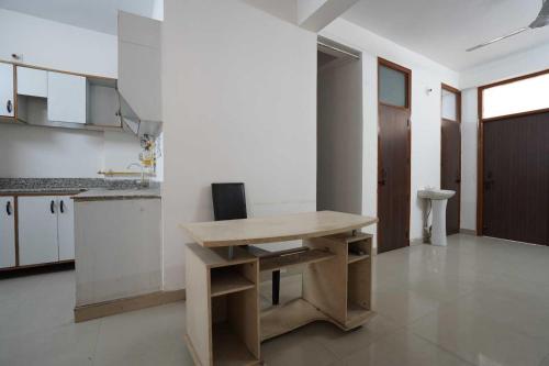 a kitchen with a wooden table in a room at Hotel O K.B in Indirapuram