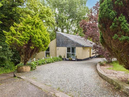 a house with a gravel driveway in front of it at Mutton Hill Cottage in Pembroke