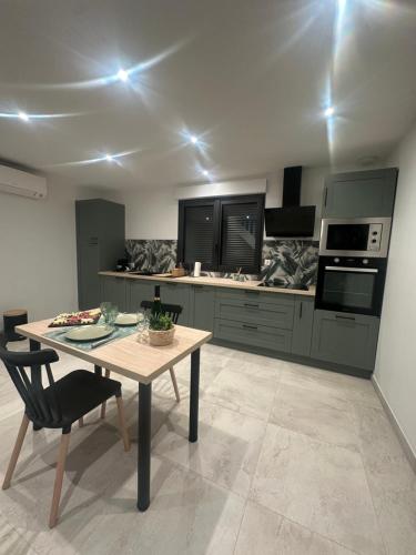 Il comprend une cuisine avec une table en bois et des appareils électroménagers. dans l'établissement L'évasion, à Martainneville