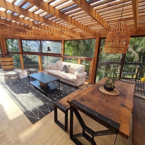 a living room with a couch and a table at CASA CON TINAJA, PISCINA Y QUINCHO - Pucón in Pucón