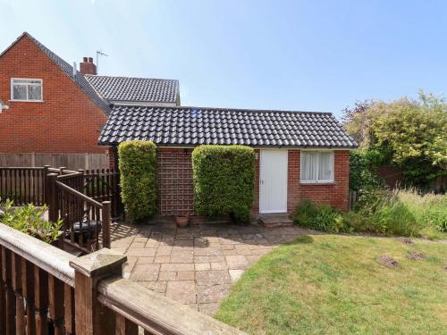 a brick house with a fence and a yard at Seadrift in Westleton