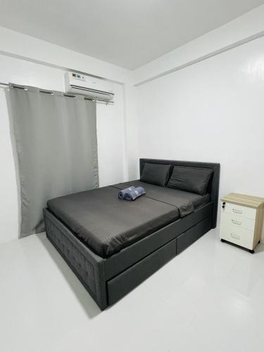 a small bedroom with a bed in a white room at Sammys House Rental in Puerto Galera