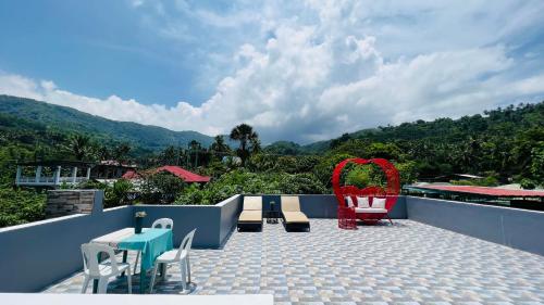 einen Balkon mit Stühlen und Tischen sowie Bergblick in der Unterkunft Sammys House Rental in Puerto Galera