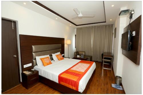 a hotel room with a bed and a television at Airport Hotel The R Blues - New Delhi in New Delhi