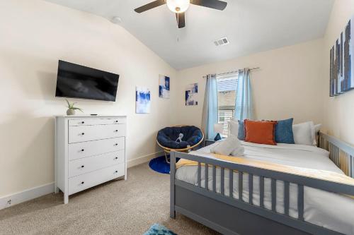 een slaapkamer met een bed, een dressoir en een tv bij Modern Townhome in Auburn in Auburn