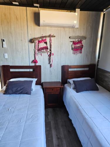two beds sitting next to each other in a room at Cabañas Litueche 1 in El Rosario
