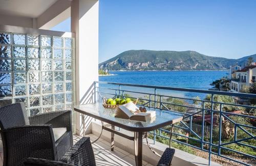 a balcony with a table and a view of the ocean at Anthis Sea View Apartment Fiskardo in Fiskardho