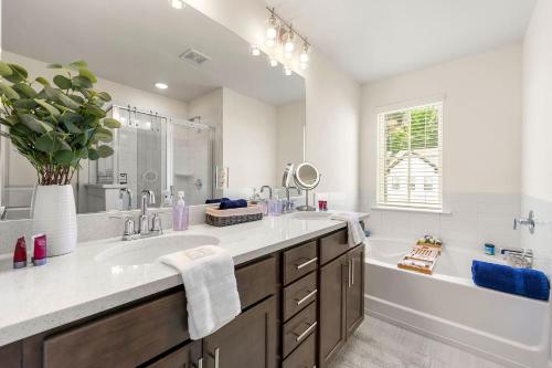 een witte badkamer met een wastafel, een bad en een wastafel bij Modern Townhome in Auburn in Auburn