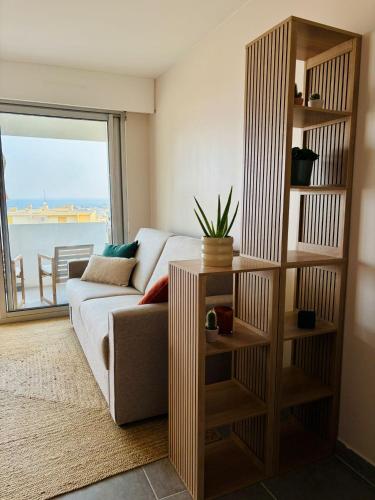 un salon avec un canapé et une étagère dans l'établissement Studio moderne et lumineux avec balcon vue mer à Bandol, à Bandol