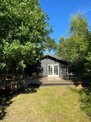 a house with a deck and a garage at Fine Details In Forest Setting In Ebeltoft in Ebeltoft