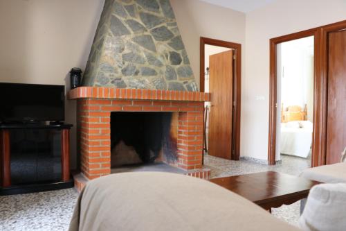 a living room with a brick fireplace with a tv at Villa Calatrue - Tabernas in Tabernas