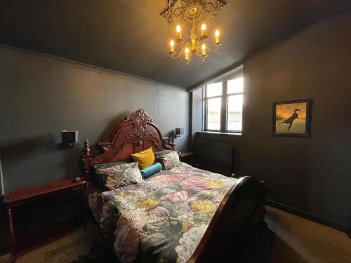 a bedroom with a bed and a chandelier at The Old Church Isle of Bute in Port Bannatyne