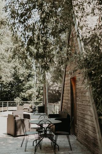 a patio with chairs and tables on a deck at La Petite Motte in Ceton
