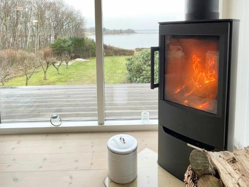 a fireplace in a living room with a window at Stunning Sunrises Over Harre Vig in Roslev
