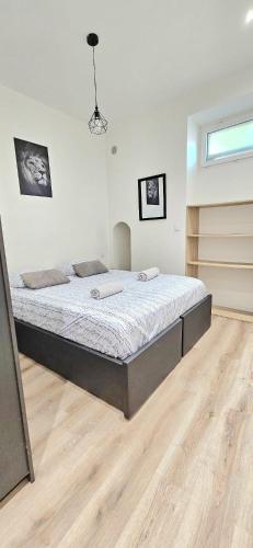 un grand lit dans une chambre avec un plancher en bois dans l'établissement T2 with Contemporary Design and air conditioning, à Nice
