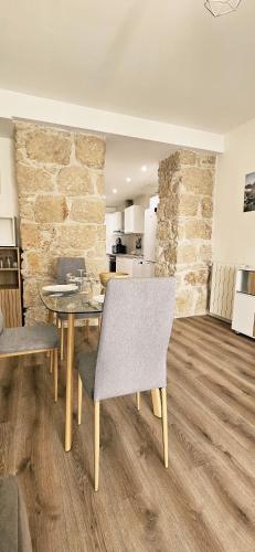 une salle à manger avec une table et des chaises et un mur en pierre dans l'établissement T2 with Contemporary Design and air conditioning, à Nice