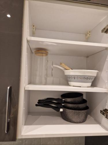 a kitchen cabinet with a shelf with a bowl and utensils at Chez Audrey Skhirat-Rabat in Skhirat