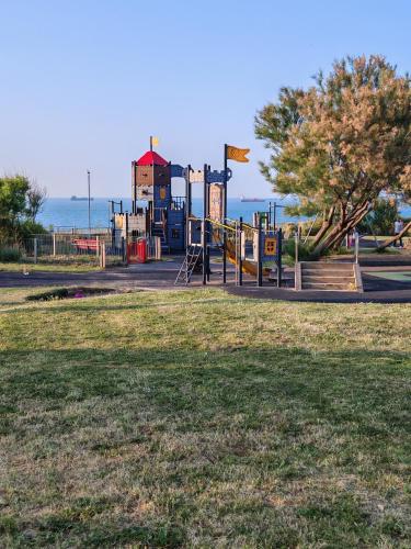 a playground in a park next to the ocean at Nest Guesthouse in Margate