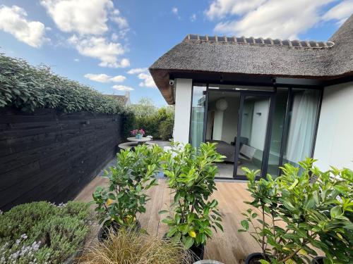 a house with a patio and a fence at Duinpoort Appartement in Castricum