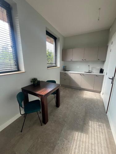 a kitchen with a table and chairs in a room at Duinpoort Appartement in Castricum