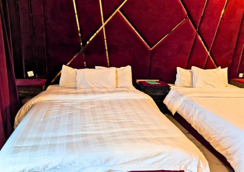 two beds sitting next to each other in a room at Grand Heights Hotel in Murree