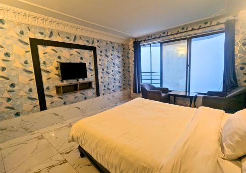 a hotel room with a bed and a television at Grand Heights Hotel in Murree