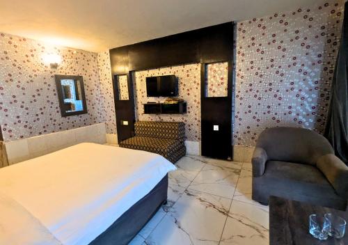 a hotel room with a bed and a chair at Grand Heights Hotel in Murree