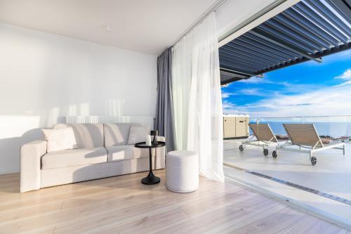 a living room with a couch and a view of the ocean at Hotel In Excelsis in Novalja