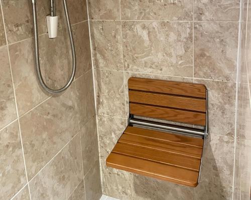 a shower with a wooden bench in a bathroom at Luxurious Private Retreat Ideal Getaway for two in East Grinstead
