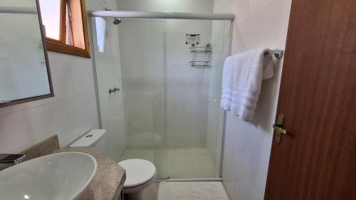 a bathroom with a shower and a toilet and a sink at Chalé Coração de Monte Verde in Monte Verde