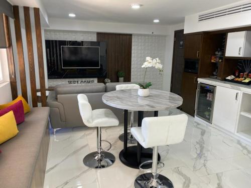 a kitchen and living room with a table and chairs at Hotel Señorial in Puerto Peñasco